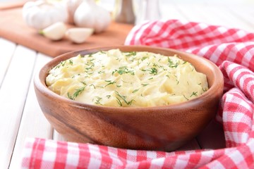 Delicious mashed potatoes with greens in bowl on table close-up