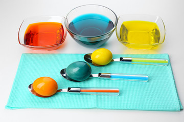 Bowls with paint for Easter eggs and eggs, isolated on white
