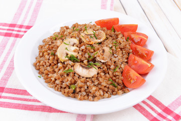 Boiled buckwheat on plate on table close-up