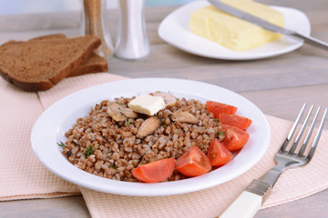 Boiled buckwheat on plate on table close-up