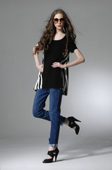 Full body fashion model posing in jeans with sunglasses