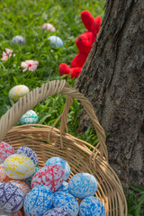 Fototapeta na wymiar Colorful Easter eggs in a basket and bunny behind the tree