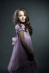 Obraz premium Adorable little girl posing in pink smart dress