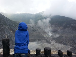 boy watching steam coming out of volcano