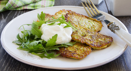Zucchini fritters with sour cream.