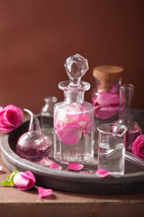 Obraz na płótnie Canvas alchemy and aromatherapy set with rose flowers and flasks