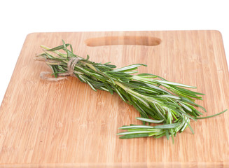 Rosemary branch on a chopping wooden board