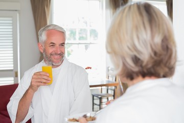 Fototapeta na wymiar Smiling mature man having breakfast with cropped woman