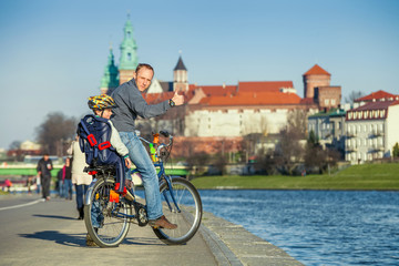 Fototapeta premium Walk on bike. Father with son cycling in city