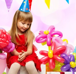 Fototapeta na wymiar Little girl in red dress sitting on gift boxes