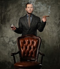 Handsome well-dressed with glass of beverage and cigar