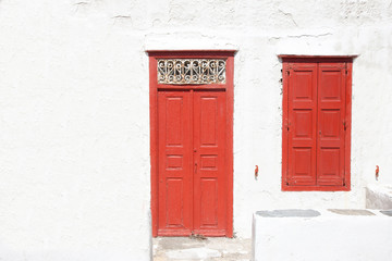 Greek house with a red door and shutters