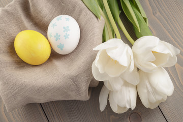 pastel color easter eggs with tulips on table