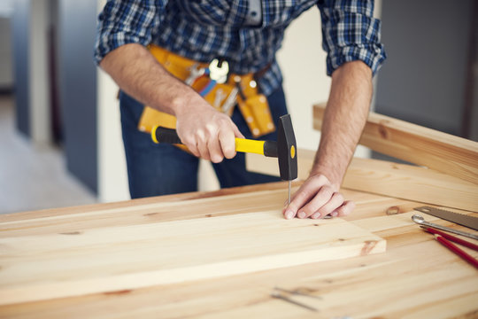 Close Up Of Man Hitting Nail By Hammer