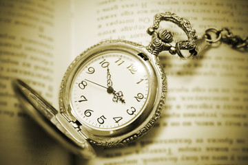 vintage pocket watch lying on the book, retro style