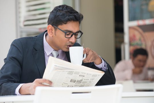 Young Indian Business Man On Laptop And Coffee At A Cafe