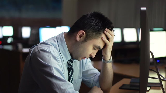 Annoyed businessman sitting in front of computer monitor