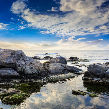 sea wave breaks about boulders