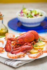 Astice rosso su un piatto contornato da gamberi