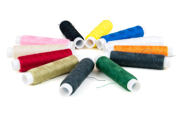 Colored spools of threads on white background