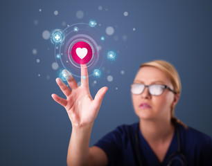 Young nurse pressing modern medical type of buttons