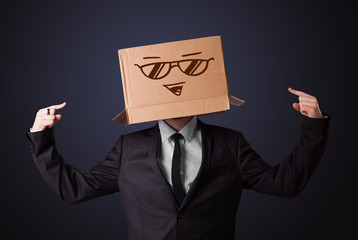 Businessman gesturing with a cardboard box on his head with smil
