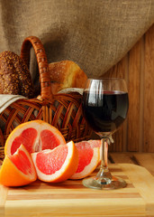 Glass of wine, grapefruit and a basket of bread