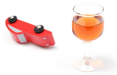 Overturned model vehicle and glass of wine. White background