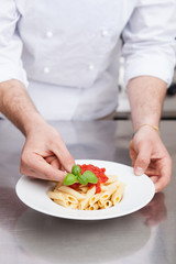 Male chef completing pasta..