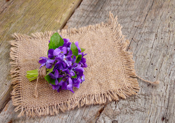 Small bouquet with meadow violets on board.