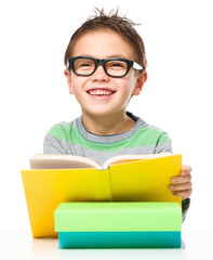 Little boy is reading a book