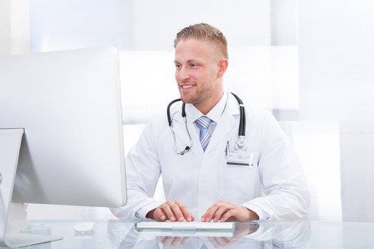 Smiling doctor or consultant sitting at a desk