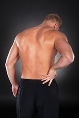 Strong muscular man with backache