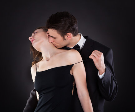 Man Kissing Woman On Neck While Removing Dress Strap
