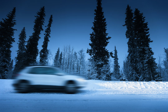 Fototapeta lights of car and winter road in forest