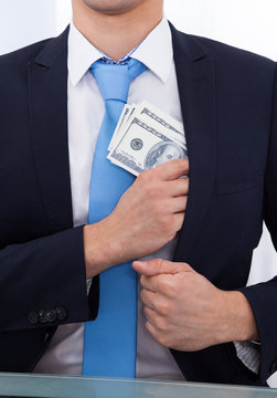 Businessman Putting Bribe Money In Pocket