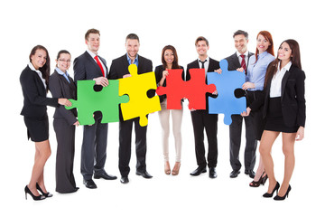 Group of businesspeople holding puzzle pieces