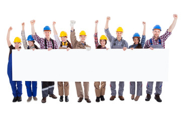 Fototapeta premium Group of workmen holding a blank white banner