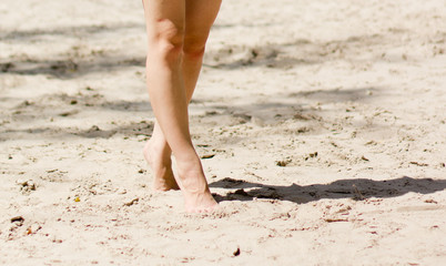 Female legs on a beach background