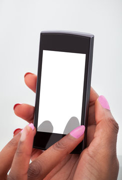 Businesswoman's Hands Using Mobile Phone In Office