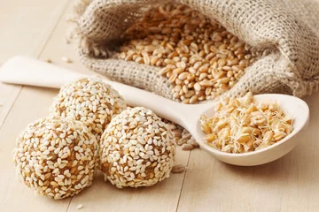 Selbstklebende Fototapeten balls from wheat sprouts with sesame seeds, sprouted grains © chamillew