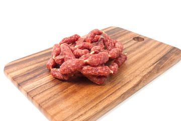 A heap of mini Salamis on wooden board