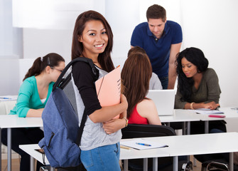 Portrait of smiling female college student carrying backpack