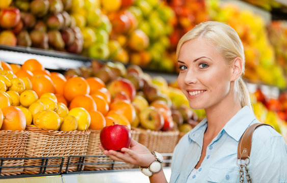 Girl at the shop choosing fruits and vegetables
