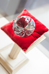 Close up of large diamond on red pillow at jeweler's shop