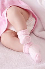 Newborn baby girl feet in pink socks