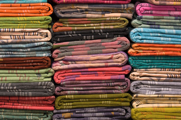 Heap of cloth fabrics at a local market in India. Close up .