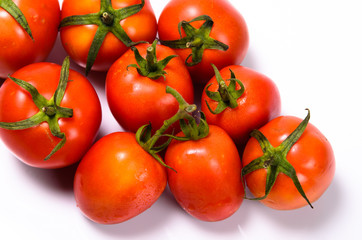 Bunch of fresh tomatoes with water drops. Isolated on white back