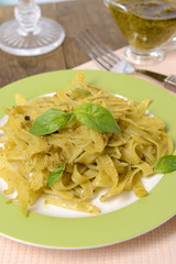 Delicious pasta with pesto on plate on table close-up