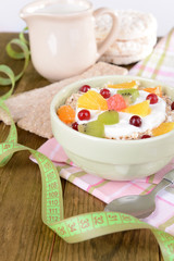 Delicious oatmeal with fruit in bowl on table close-up
